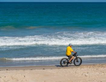 Man biking on the beach.