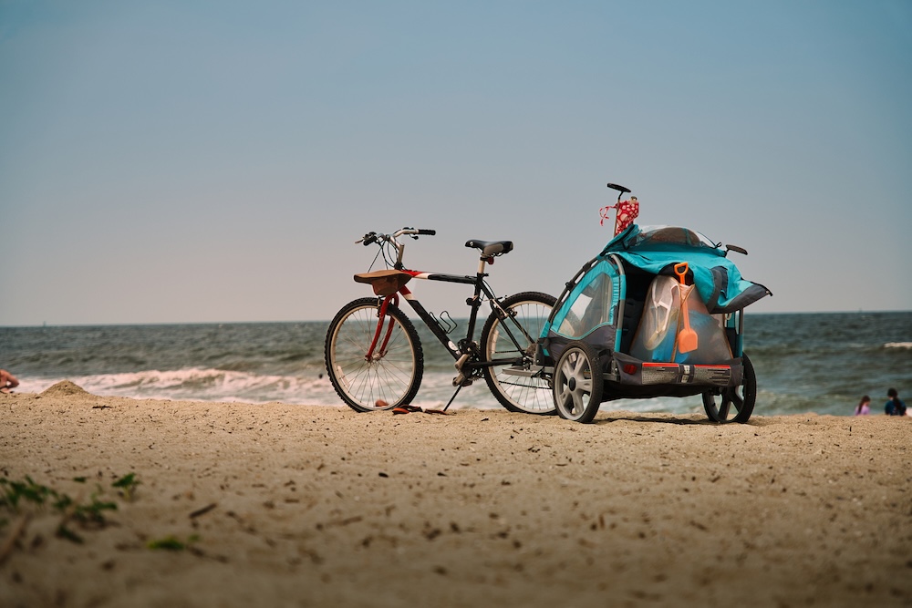 Family Beach Day with Bicycle and Child Trailer on Florida Coastline.