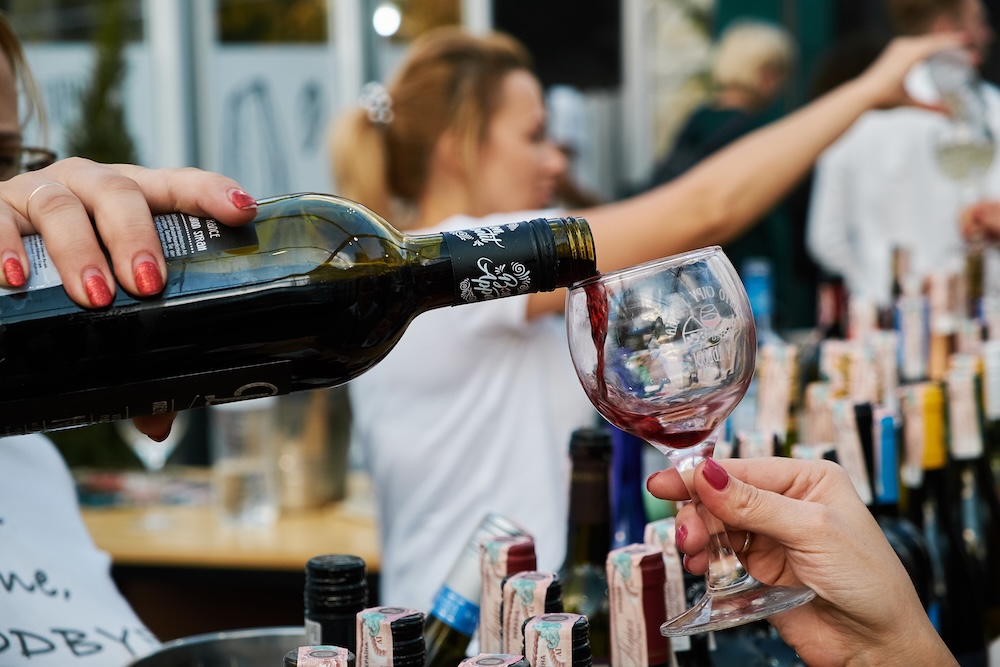hand pours wine into a glass